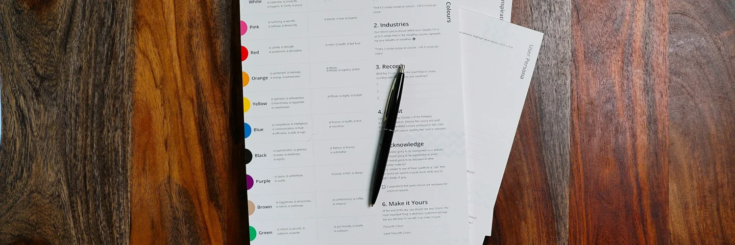 Printed documents stacked on a wooden desk