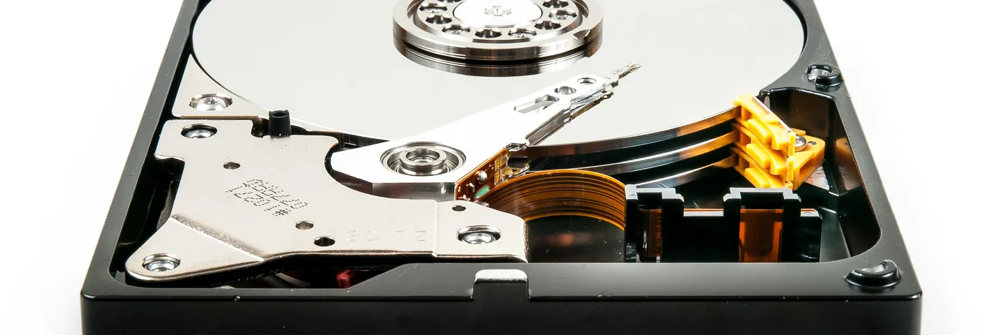 An opened hard drive showing its platter and read/write arm